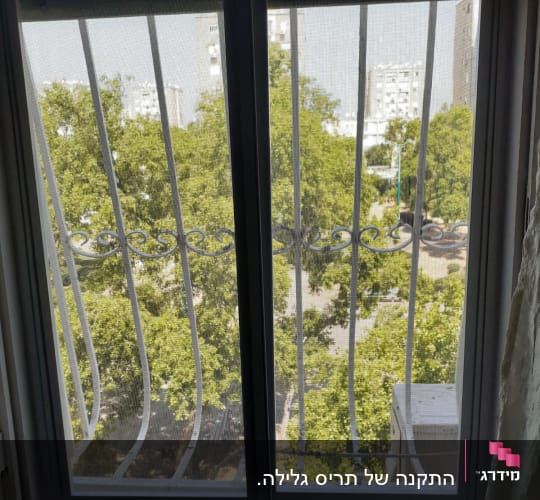 חלון אלומיניום עם סורגי מתכת נראים מבחוץ
